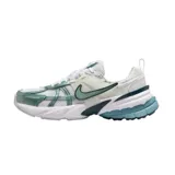Championes Nike V2K Run de estilo retro-futurista, con diseño en capas de malla y material sintético en tonos beige y gris. Presenta una entresuela robusta con tecnología Cushlon y el logo de Nike en el lateral.
