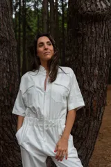 Mono blanco de gabardina de algodón, corte clásico con cierre frontal, pantalón largo con bolsillos, manga corta y cintura fruncida en la espalda.