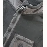 Campera de polar negro con cierre frontal completo, cuello alto y bolsillo en el pecho con cierre. Presenta detalles en tela técnica en el cuello, cierre y bolsillo.