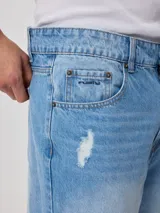 Bermuda de jean celeste con roturas y terminación desflecada.