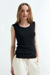 Top tejido sin mangas color negro, con escote geométrico y diseño ajustado.
