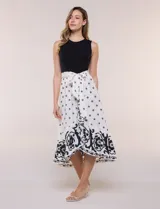 Vestido midi combinado de corte fluido. Presenta un torso ajustado acanalado sin mangas, con cuello redondo y sisas clásicas. Cuenta con cintura elastizada con lazo para anudar y falda evasé con estampado floral y geométrico, finalizando con un volante en el ruedo.