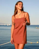 Vestido corto marrón de lino y rayón, con escote recto, tirantes finos y tajo lateral.