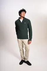 Sweater de punto acanalado en color verde oscuro, con cuello alto y cierre frontal parcial de un cuarto. Presenta puños y ruedo elásticos, con el logo de la marca bordado en el pecho.