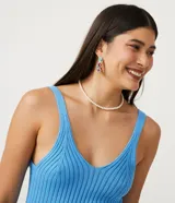Blusa musculosa estilo cropped de Blue Steel, confeccionada en tejido de viscosa con textura acanalada. Presenta escote en V y tirantes medios elásticos.