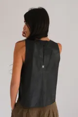 Chaleco azul marino de gamuza sintética con bordado de sol en el pecho, sin mangas y corte recto.