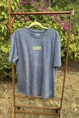 Remera blanca de manga corta con cuello redondo y estampado amarillo con la frase "Última Ronda".