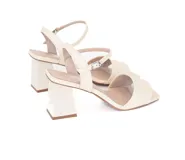 Sandalias de cuero color beige claro, con taco bloque medio y tiras cruzadas en la parte delantera y en el tobillo con hebilla ajustable.