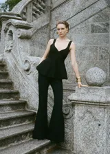 Top de punto fino con diseño peplum, escote en pico y tirantes anchos. Presenta un corte entallado en el torso que se abre en la cintura y espalda abierta.