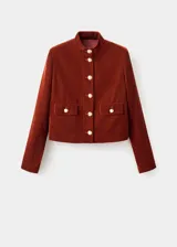 Chaqueta corta de terciopelo color marrón, con cuello mao, cierre frontal de botones dorados y dos bolsillos con solapa en el frente.