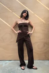 Pantalón de tiro alto color marrón, confeccionado en tejido efecto ante. Presenta trabillas, falsos bolsillos de vivo en el delantero y cierre frontal con cremallera y gancho metálico.