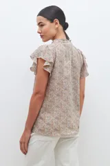 Blusa estampada con cuello mao y mangas cortas con volados.