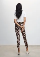 Pantalon skinny crop de tiro medio con diseño estampado geométrico en tonos marrón y blanco. Cuenta con trabillas, bolsillos laterales, bolsillos de ribete traseros y cierre de cremallera con botón.