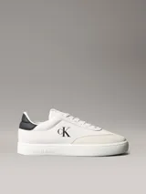 Zapatillas de ante Calvin Klein de color blanco, con detalles en contraste negro en el talón e inserciones de ante en la puntera. Cuentan con cordones blancos, suela de goma y el monograma de la marca en el lateral y la lengüeta.