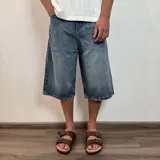 Bermuda de jean negro con corte ancho y largo a la rodilla.