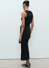 Vestido midi negro sin mangas, con cuello redondo, tirantes anchos, diseño recto y detalle de nudo en la cintura.