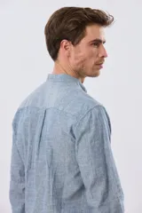 Camisa de lino y algodón color blanco, con cuello mao, manga larga y cierre frontal de botones. Presenta un pequeño logo bordado en el pecho.