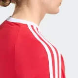 Remera Adidas roja de manga corta con cuello redondo y las clásicas tres franjas blancas en los hombros y mangas. Incluye el logo de Adidas en el pecho.
