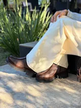 Bota corta de cuero en tonos chocolate, con diseño de paneles texturizados y suela track robusta de goma.