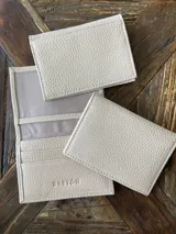 Tarjetero de cuero vacuno color dorado, con ranuras para tarjetas y bolsillo exterior en la parte trasera. Marca Bretoni.