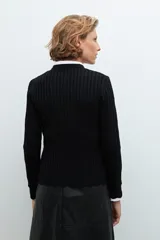 Cardigan negro de punto acanalado, con cuello redondo y cierre frontal de botones plateados.