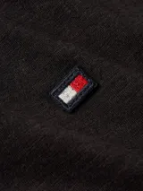 Remera negra de corte slim, cuello redondo y manga corta con dobladillo. Logo de Tommy Hilfiger bordado en el pecho.