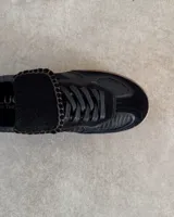 Championes de cuero vacuno con diseño de paneles en tonos marrones y detalles en blanco. Presentan una combinación de texturas lisas y grabadas, con cordones planos y costuras decorativas en la lengüeta.