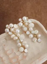 Aros colgantes de diseño artesanal, compuestos por una estructura de alambre dorado que sostiene un racimo de perlas cultivadas y discos de nácar de distintos tamaños.