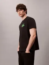 Remera de Calvin Klein en color negro con cuello redondo y mangas cortas, confeccionada en suave punto de algodón. Presenta un estampado gráfico en contraste en el pecho con la leyenda "ALL" y la firma de la marca debajo.