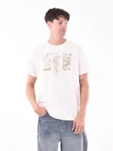 Remera blanca con rayas horizontales finas y estampado frontal con tres rectángulos con imágenes de la naturaleza.