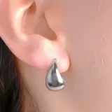 Aros tipo argolla pequeña con diseño de gota lisa y acabado brillante.