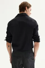 Camisa de corte slim fit en tejido elástico de mezcla de algodón, con cuello italiano, tapeta lisa y mangas largas con puños ajustables. Presenta un bajo levemente redondeado y canesú en la espalda.