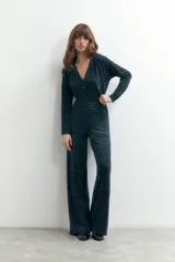 Mono largo de punto color gris oscuro con lurex, escote en V y cierre frontal con un botón. El pantalón es de corte palazzo.