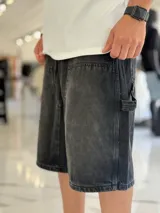 Bermuda de jean estilo carpintero, color celeste, con bolsillos laterales amplios, presilla para herramientas y diseño amplio de corte oversize.