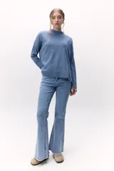 Sweater de lana color crema, de cuello alto y corte holgado.