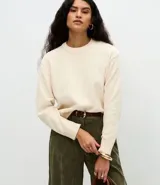 Suéter de tejido chenille con cuello redondo acanalado, mangas largas y puños reforzados. Presenta un corte regular y una textura suave y aterciopelada.