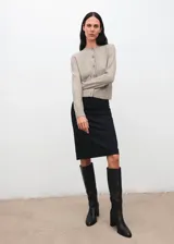 Cardigan de punto de corte recto con cuello redondo y cierre frontal de botones. Presenta mangas largas con puños acanalados y un diseño clásico de tejido de punto medio.