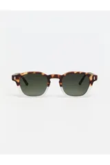 Lentes de sol Tiwi modelo Lucien con armazón bicolor, parte superior en estampado carey y parte inferior transparente. Cuentan con cristales oscuros y detalles metálicos en las esquinas.