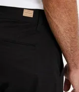 Pantalón de corte slim confeccionado en tejido de sarga de algodón con un toque de elastano. Presenta cierre de botón y cremallera, trabillas en la cintura y bolsillos laterales y traseros.