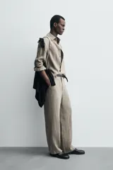 Camisa de manga larga color verde oliva, confeccionada en lino lavado con efecto ligeramente arrugado. Presenta cuello italiano y cierre frontal de botones.