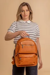 Mochila de cuero sintético color suela, con compartimento principal amplio, bolsillo frontal con cierre y correas ajustables.