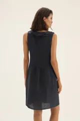 Vestido azul marino de lino, corte recto, sin mangas, con escote en V con volados y cordón ajustable.