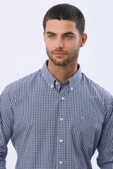 Camisa de manga larga con estampado de cuadros pequeños en tonos rojo, azul y blanco. Presenta cuello abotonado, cierre frontal con botones y un bolsillo pequeño en el pecho.