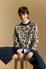 Sweater de punto con diseño jacquard de animal print, de silueta relajada y manga larga. Presenta cuello redondo y puños acanalados en color azul marino en contraste.