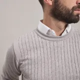 Sweater azul marino de punto trenzado, con cuello redondo y mangas largas.