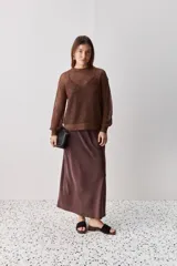 Sweater calado de punto negro, con cuello redondo y mangas largas, de diseño liviano ideal para superposiciones.