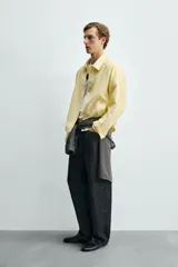 Sobrecamisa relaxed fit de color amarillo claro, confeccionada en tejido con mezcla de lyocell. Presenta cuello solapa, mangas largas raglán con puños abotonados, bolsillos de vivo en la cadera y cierre frontal con botonadura.