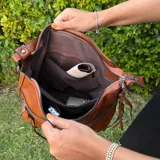 Bolso tipo tote color marrón confeccionado en eco-cuero suave con textura premium. Incluye monedero a juego, cierre superior seguro y bolsillos internos.