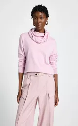 Polera de punto fino color rosa, con cuello holgado tipo cowl y mangas largas con puños ajustados.