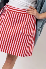 Pollera short cruzada con diseño a rayas verticales rojas y blancas, cintura elástica y bolsillos laterales cargo.